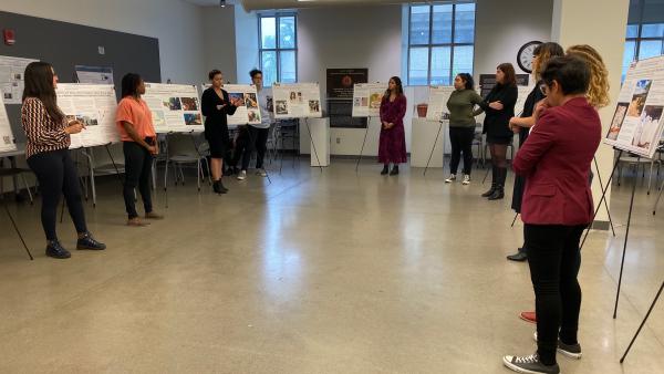 Photograph of graduate students standing in a half circle by their research posters