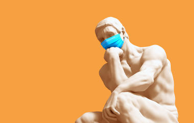 Photograph of classical thinker sculpture wearing face mask