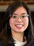 Photograph of woman's smiling face, wearing glasses, long dark hair