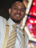 Photograph of man standing in front of a stained glass window