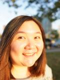 Smiling woman with long dark hair standing outside