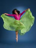 Woman in dance pose wearing pink and green dress