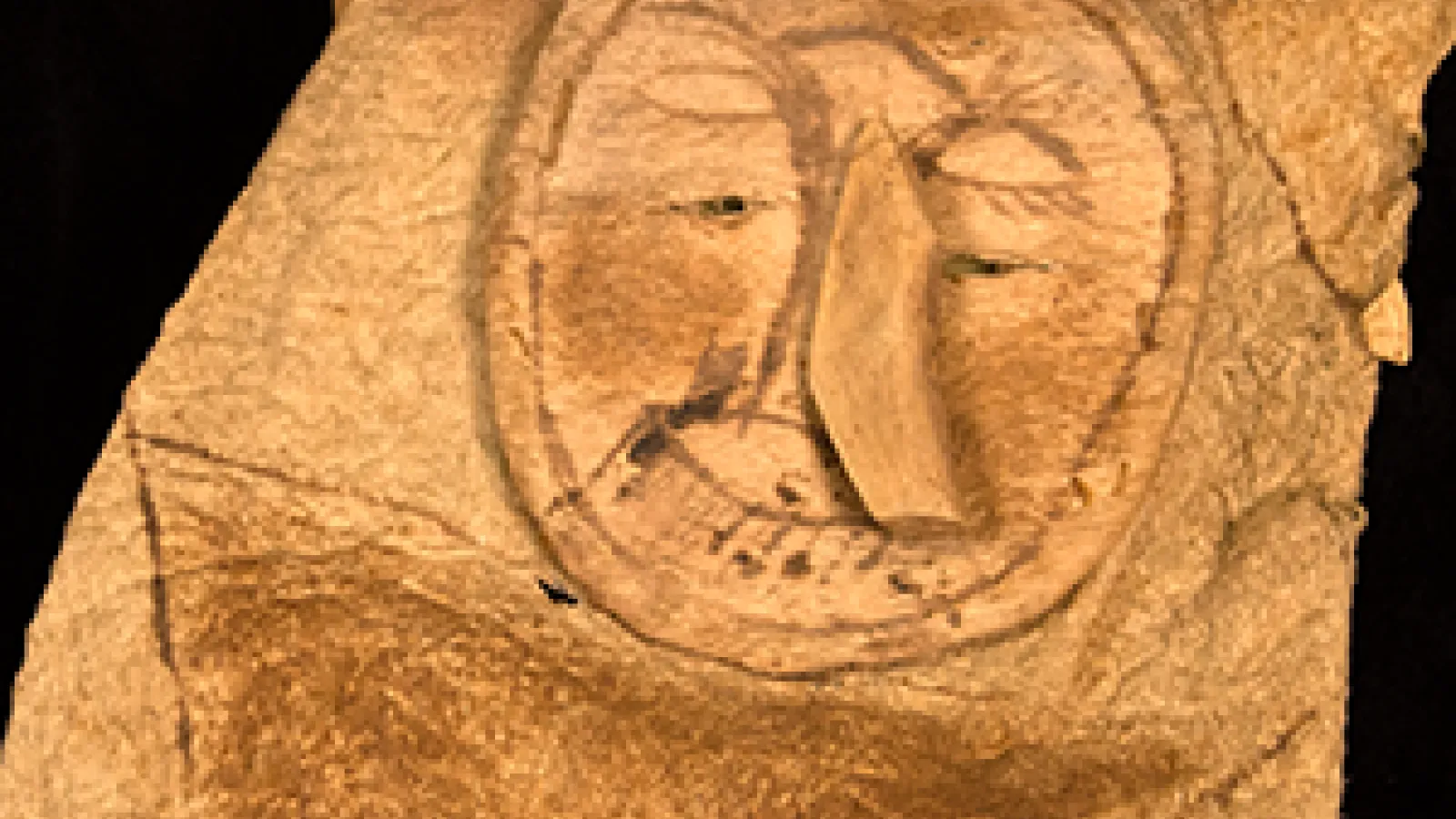 Leather artifact with a face on it