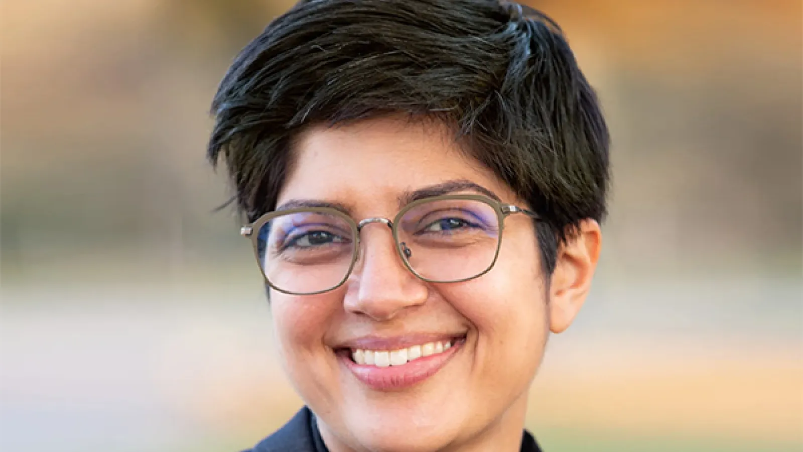 Smiling woman with short dark hair and glasses