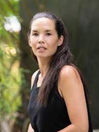 Photograph of woman with long hair and black shirt standing outdoors