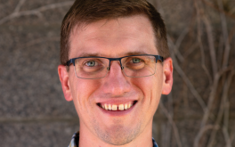 A man wearing glasses and smiling