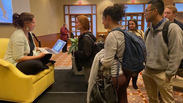 Photograph of Becca Heller speaking with students after the event