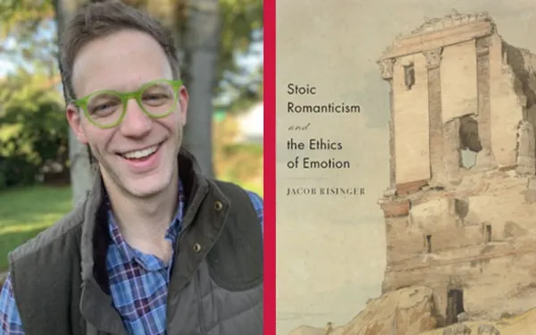 Smiling man standing outdoors next to book cover