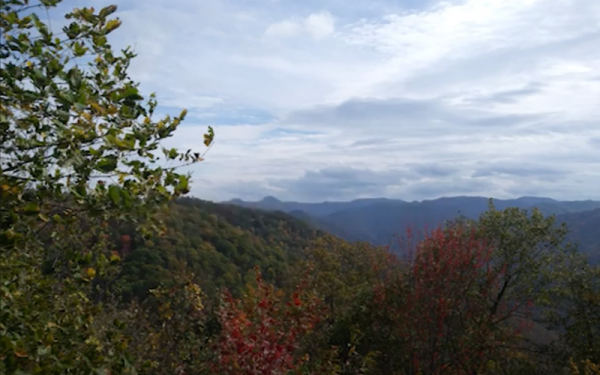 Photograph of a mountainous hillside and clouded sky