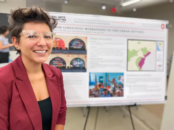 Graduate student with their research poster
