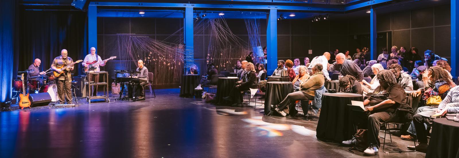 Performance venue with attendees and musicians