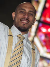 Man standing in front of a stained glass window