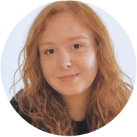 Smiling woman with long red hair and a dark shirt